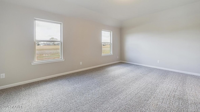 carpeted spare room featuring baseboards