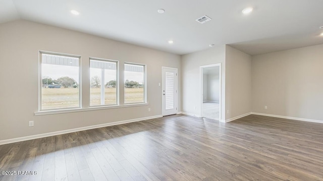 empty room featuring dark wood-type flooring, recessed lighting, baseboards, and visible vents