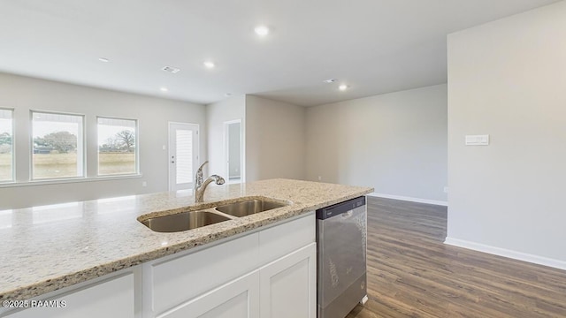 kitchen with a sink, light stone counters, stainless steel dishwasher, dark wood-style floors, and white cabinets