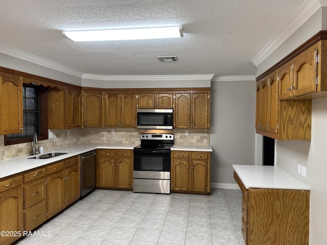 kitchen with brown cabinetry, visible vents, appliances with stainless steel finishes, and a sink