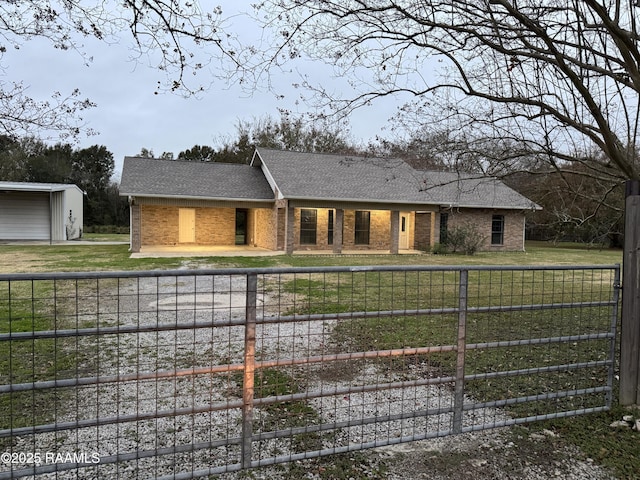 view of front of home featuring a front lawn, a fenced front yard, brick siding, and roof with shingles