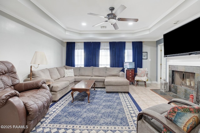 living area featuring a raised ceiling, visible vents, tile patterned floors, and ornamental molding