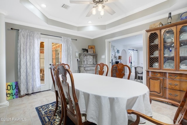 dining space with visible vents, plenty of natural light, french doors, a raised ceiling, and ceiling fan