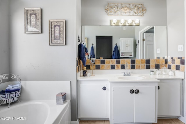 full bath featuring vanity, a bath, and backsplash