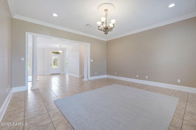 spare room featuring baseboards, decorative columns, an inviting chandelier, and ornamental molding