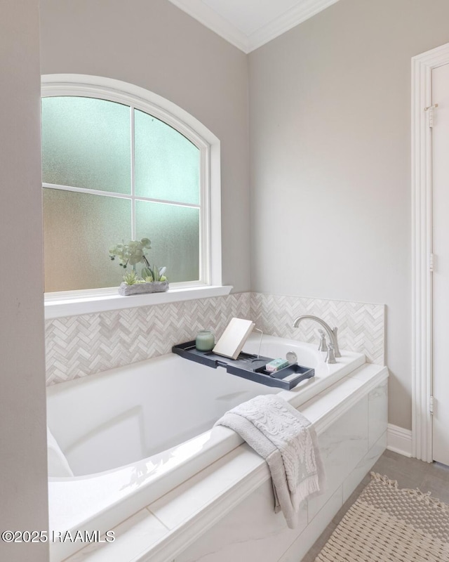 bathroom with crown molding and a garden tub