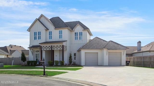 view of front of house with board and batten siding, fence, a front yard, driveway, and an attached garage