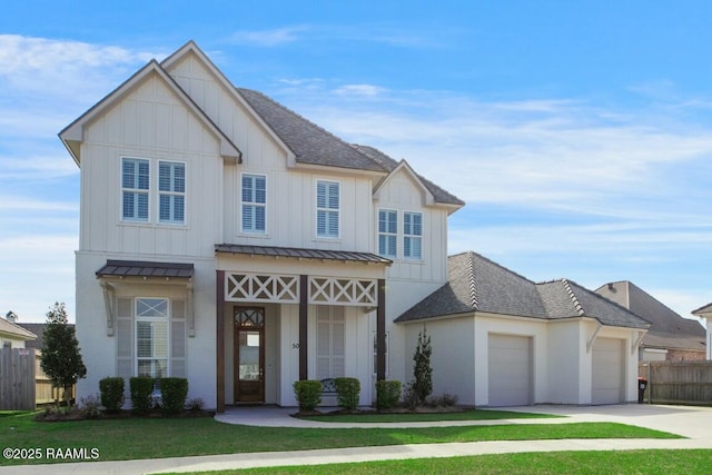 view of front of property featuring board and batten siding, concrete driveway, an attached garage, and fence