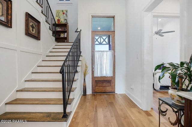 entryway with stairway, light wood-style flooring, and baseboards