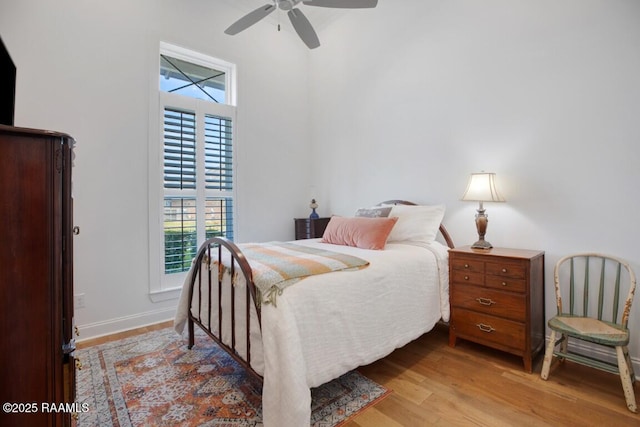 bedroom featuring ceiling fan, baseboards, and light wood-style flooring