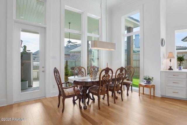 dining area with light wood-type flooring and baseboards