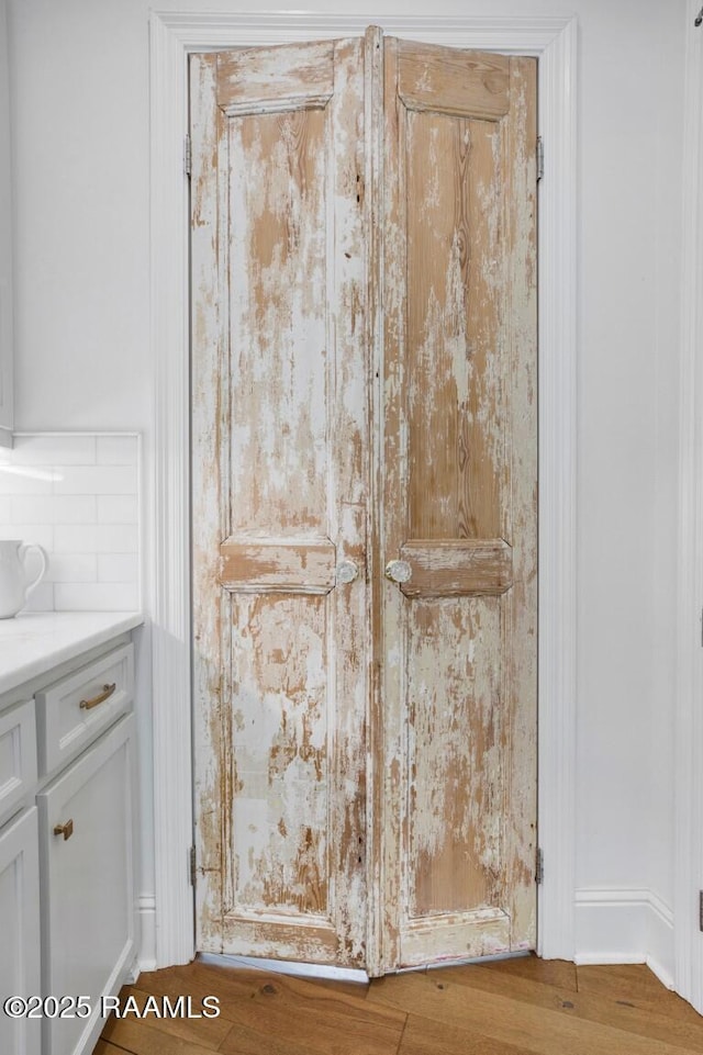 room details featuring backsplash and wood finished floors