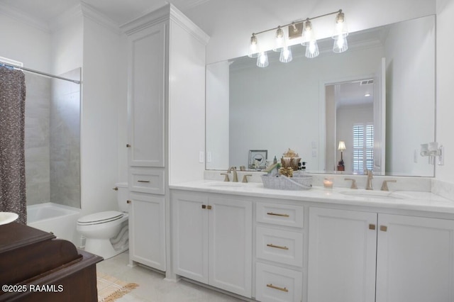 full bathroom with double vanity, toilet, crown molding, and a sink