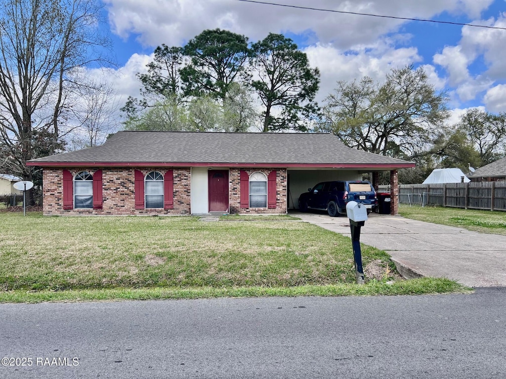 view of front of property featuring concrete driveway, a carport, brick siding, and a front lawn