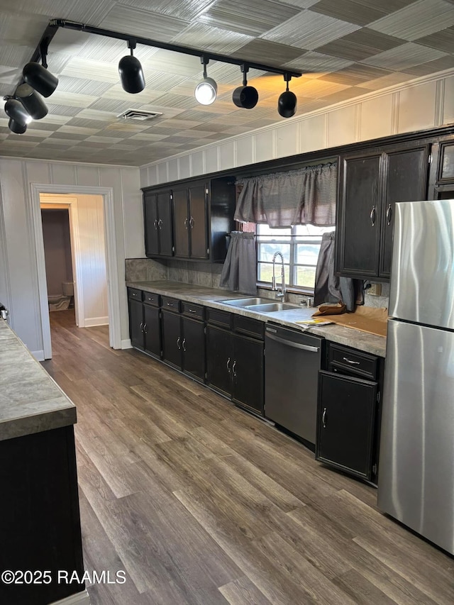 1107 Railroad St, Pine Prairie, LA 70576 - kitchen featuring dark cabinetry, wood finished floors, visible vents, and stainless steel appliances