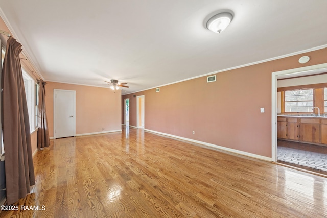 unfurnished room featuring crown molding, a ceiling fan, visible vents, and light wood finished floors