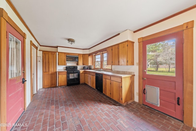 kitchen with brick floor, a sink, black appliances, light countertops, and crown molding