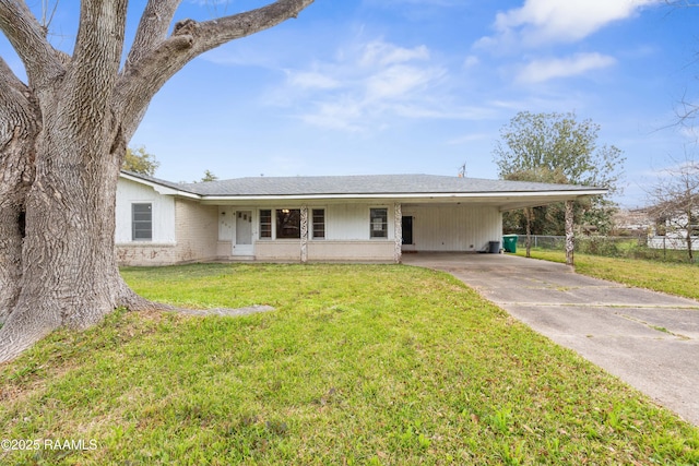 ranch-style house with brick siding, fence, concrete driveway, a front yard, and a carport