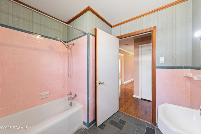 full bath featuring a wainscoted wall, wallpapered walls,  shower combination, ornamental molding, and tile walls