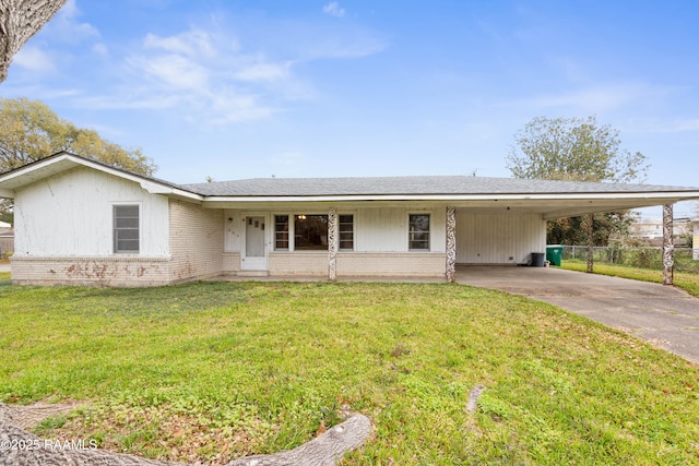 ranch-style home featuring a carport, fence, concrete driveway, a front yard, and brick siding