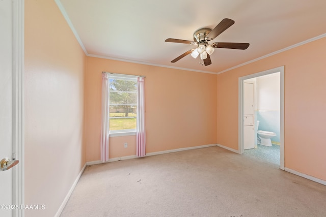 spare room featuring light colored carpet, baseboards, a ceiling fan, and crown molding