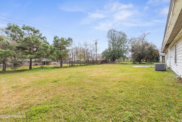 view of yard with central air condition unit and fence