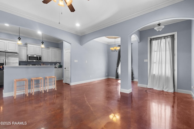 interior space featuring baseboards, arched walkways, stainless steel appliances, and ceiling fan