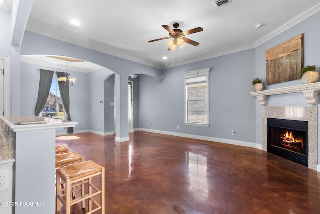 living area with a ceiling fan, baseboards, concrete floors, arched walkways, and a lit fireplace