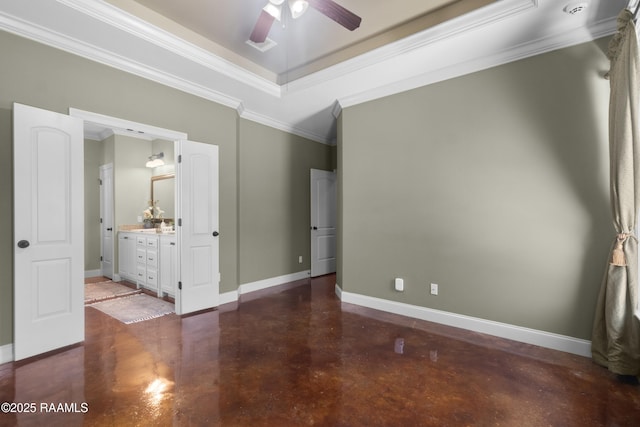 unfurnished bedroom with finished concrete flooring, a tray ceiling, baseboards, and ornamental molding