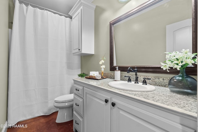 bathroom featuring toilet, vanity, and a shower with shower curtain