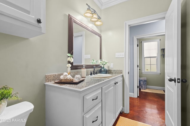 bathroom featuring vanity, baseboards, concrete floors, crown molding, and toilet