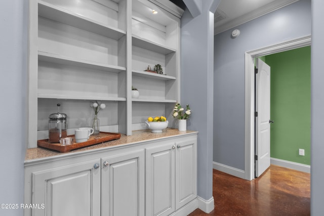 bar featuring ornamental molding, baseboards, and finished concrete floors