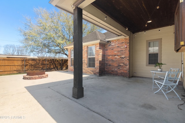 view of patio / terrace with a fire pit and fence