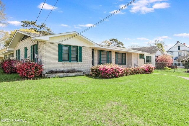 ranch-style home with brick siding, a front yard, and fence