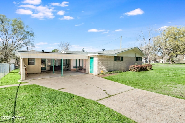 view of front facade with a carport, fence, concrete driveway, a front yard, and brick siding