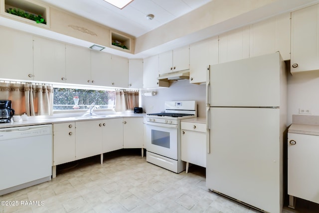 kitchen featuring white appliances, light countertops, under cabinet range hood, and a sink