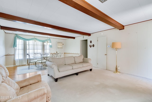 living area with beam ceiling and a notable chandelier