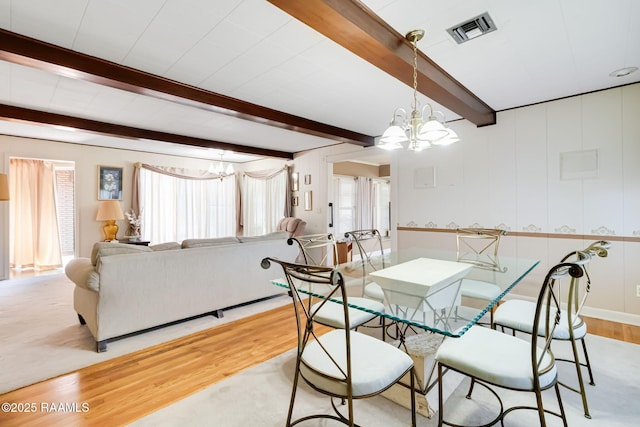 dining room with visible vents, beam ceiling, a notable chandelier, and light wood-style flooring