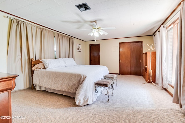 bedroom featuring light carpet, visible vents, crown molding, and ceiling fan