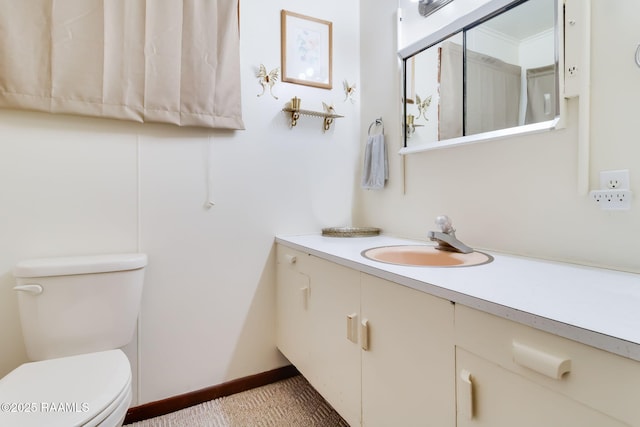 bathroom featuring vanity, toilet, and baseboards