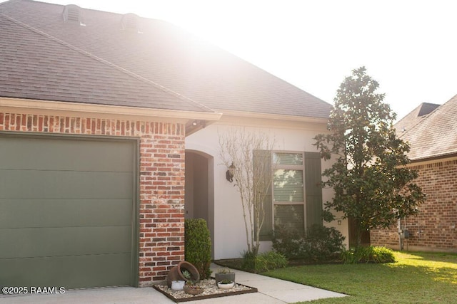 doorway to property with a garage, a lawn, brick siding, and a shingled roof