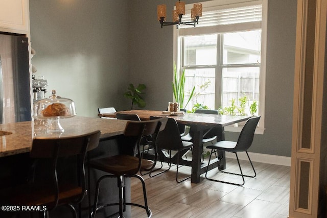 dining room featuring baseboards and an inviting chandelier