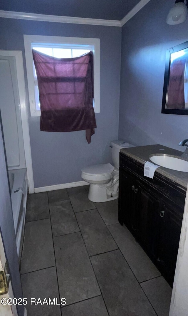 bathroom with baseboards, toilet, ornamental molding, and vanity