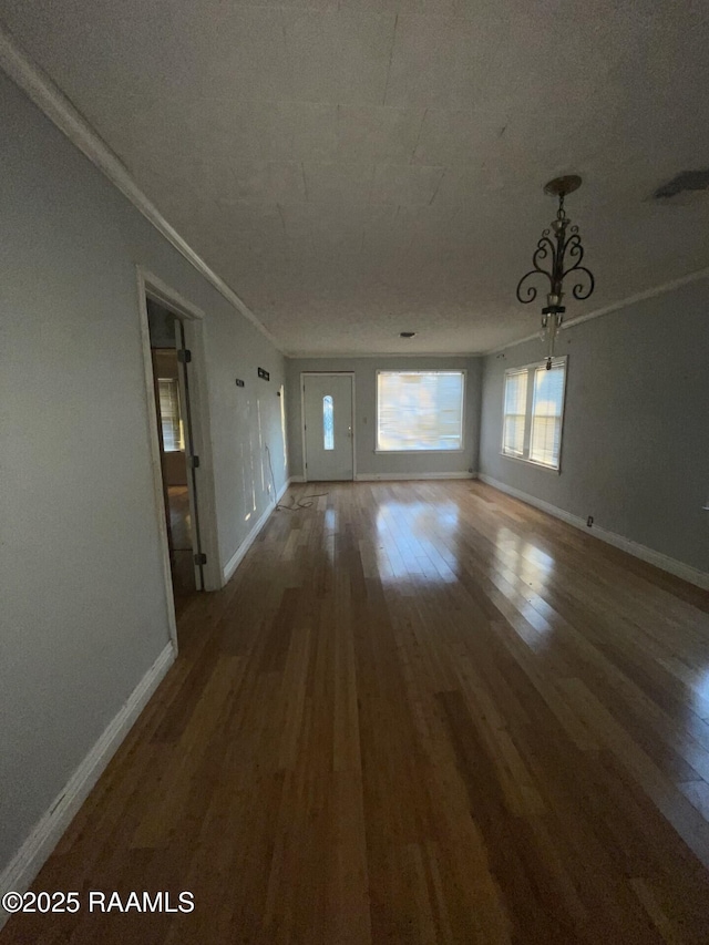 interior space with baseboards, wood finished floors, and ornamental molding