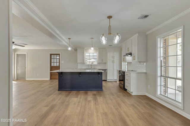 kitchen featuring visible vents, a breakfast bar, black electric range, under cabinet range hood, and crown molding