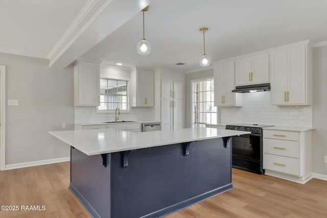 kitchen with under cabinet range hood, crown molding, light countertops, and black range with electric stovetop