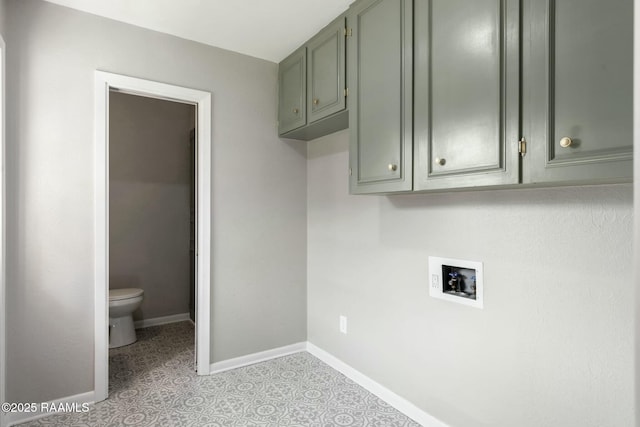 washroom with cabinet space, baseboards, and hookup for a washing machine