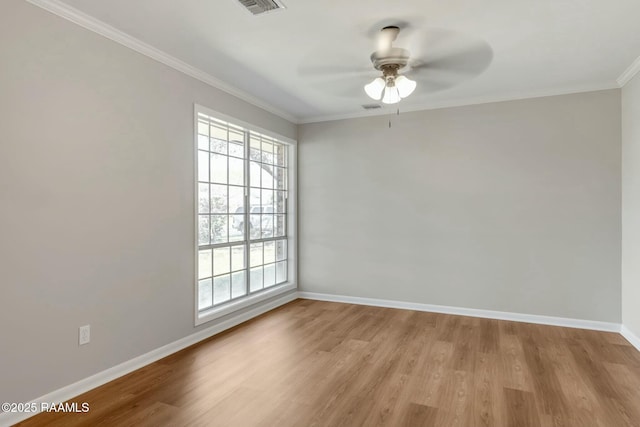 empty room featuring visible vents, a ceiling fan, light wood-style floors, crown molding, and baseboards