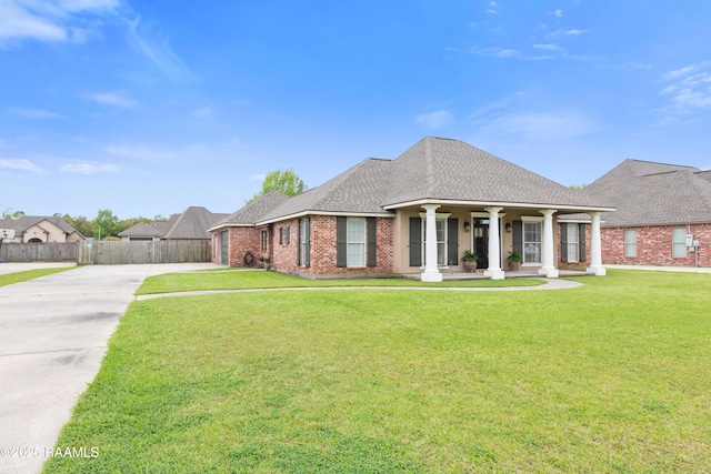view of front facade with fence, brick siding, a front lawn, driveway, and covered porch
