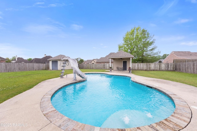 view of swimming pool featuring a fenced backyard, a water slide, and a lawn